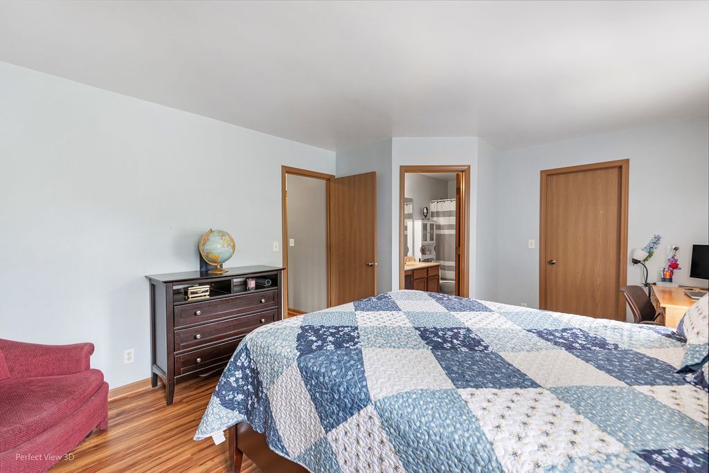 22202 West Niagara Trail, Unit 22202 Plainfield, IL 60544 - Photo 18 of 24 a bedroom with a bed and wooden floor