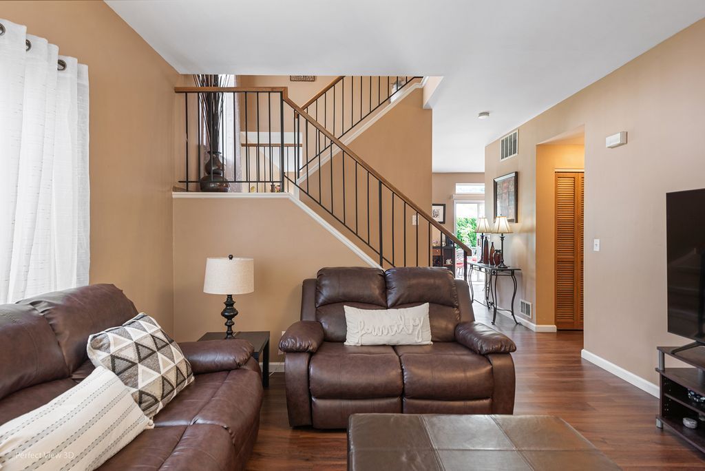 22202 West Niagara Trail, Unit 22202 Plainfield, IL 60544 - Photo 3 of 24 a living room with furniture ceiling fan and a wooden floor