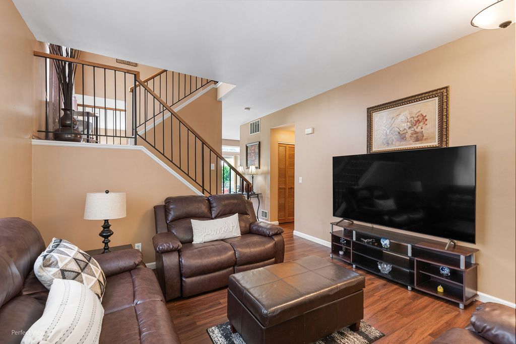 22202 West Niagara Trail, Unit 22202 Plainfield, IL 60544 - Photo 4 of 24 a living room with furniture and a flat screen tv