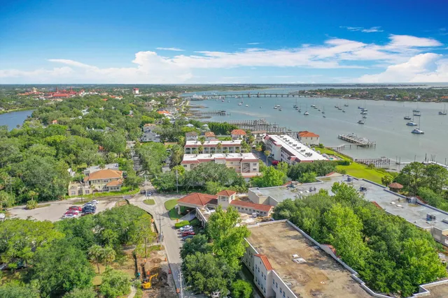 an aerial view of a city with lots of residential buildings ocean and mountain view in back