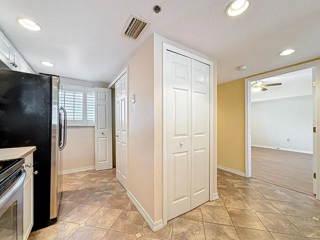 a kitchen with a refrigerator sink and cabinets
