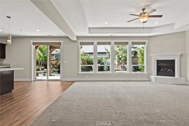 a view of a livingroom with kitchen and chandelier fan