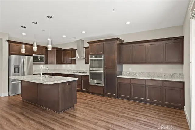 a large kitchen with stainless steel appliances kitchen island granite countertop a large counter top and wooden cabinets