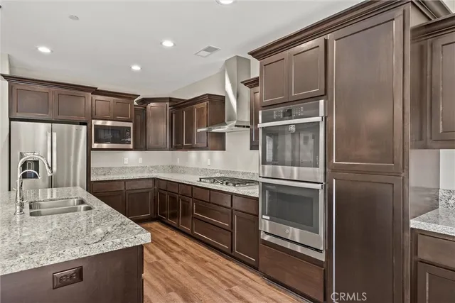 a kitchen with stainless steel appliances granite countertop a sink stove and wooden floor
