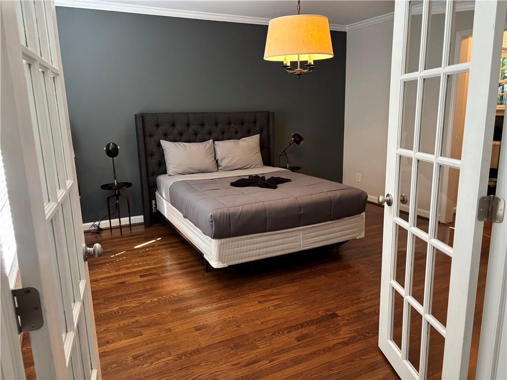 45 Blackland Road Northwest Atlanta, GA 30342 - Photo 14 of 31 a bedroom with a bed and wooden floor