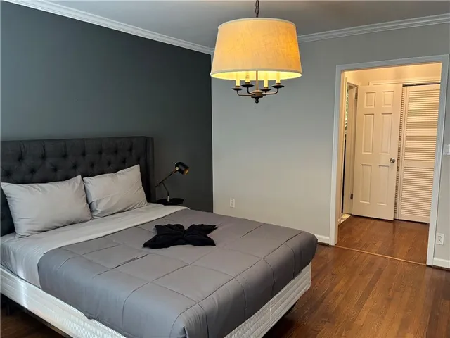 a bedroom with a bed and a painting on the wall