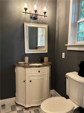 a bathroom with a toilet sink and mirror