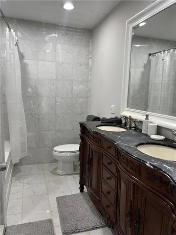 a bathroom with a granite countertop sink toilet a mirror and shower