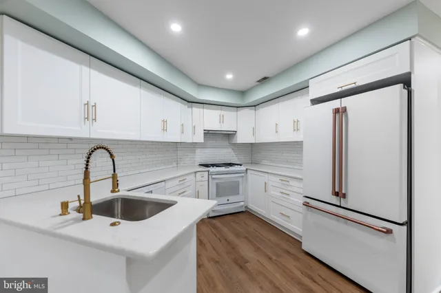 a kitchen with a refrigerator a sink and cabinets