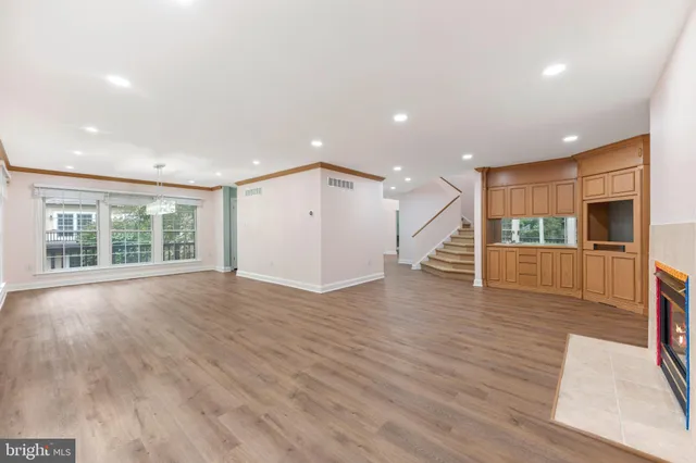 a view of empty room with wooden floor and fireplace