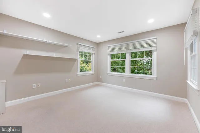 an empty room with windows and cabinet