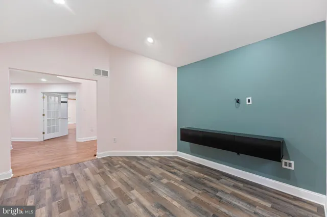 a view of empty room with wooden floor and window