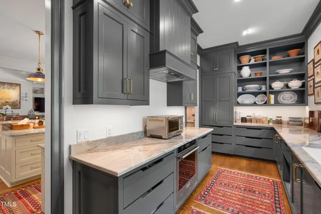 a utility room with stainless steel appliances white cabinets and a sink