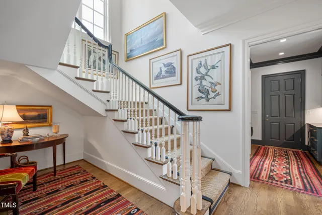 a bedroom with a bed lamp and paintings on the wall