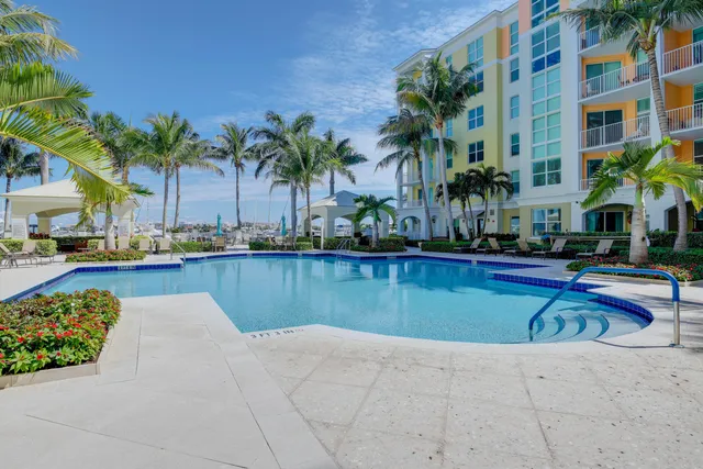 a view of swimming pool with outdoor seating and house in the background