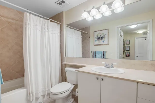 a bathroom with a sink vanity mirror and toilet