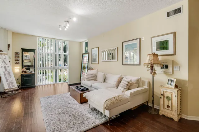 a living room with furniture large window and wooden floor