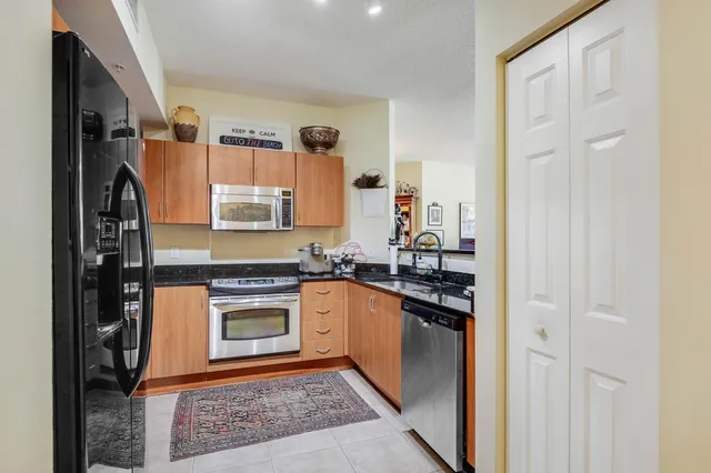 a kitchen with stainless steel appliances granite countertop a stove top oven a sink and dishwasher