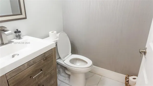 a white toilet sitting next to a bathroom sink