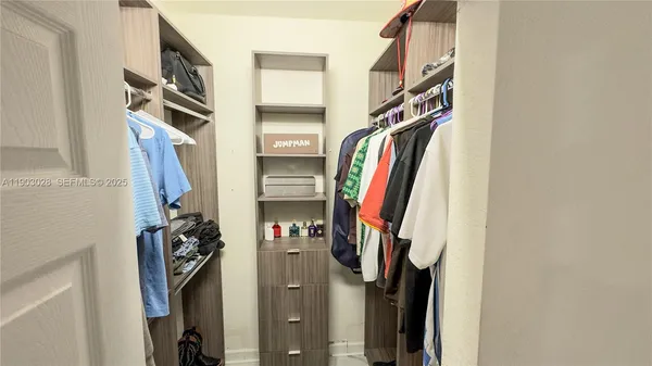 a view of walk in closet with clothes
