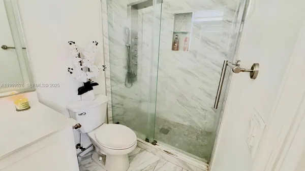 a white toilet sitting next to a bathroom sink