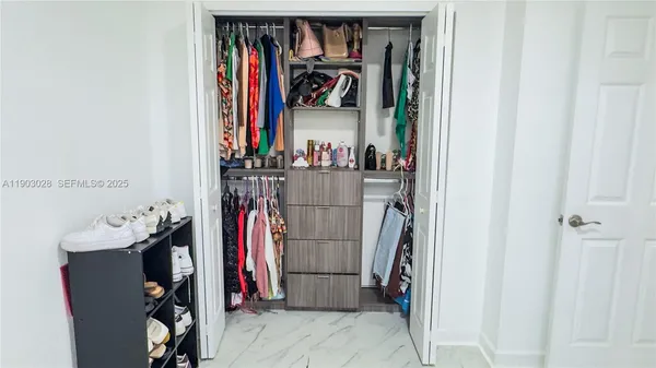 a view of walk in closet with clothes