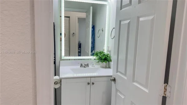 a bathroom with a sink and mirror with toilet
