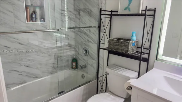 a bathroom with a shower toilet and sink