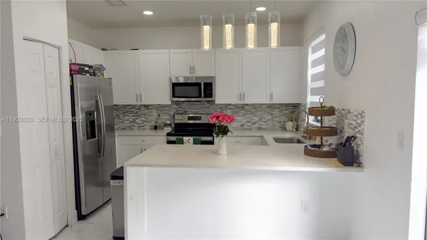 a kitchen with stainless steel appliances a refrigerator sink and stove