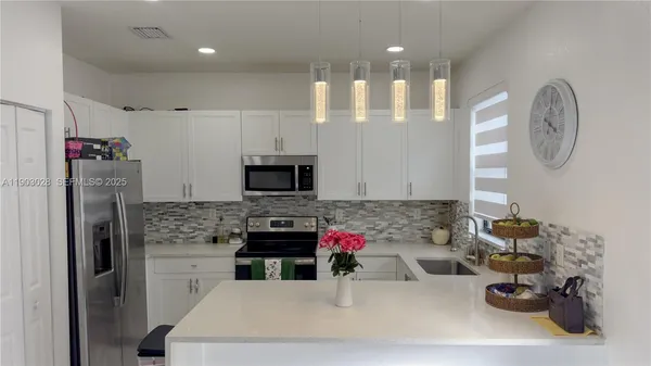 a kitchen with kitchen island granite countertop a sink appliances and cabinets