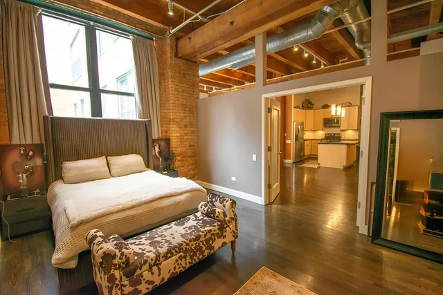 a bedroom with a bed and wooden floor