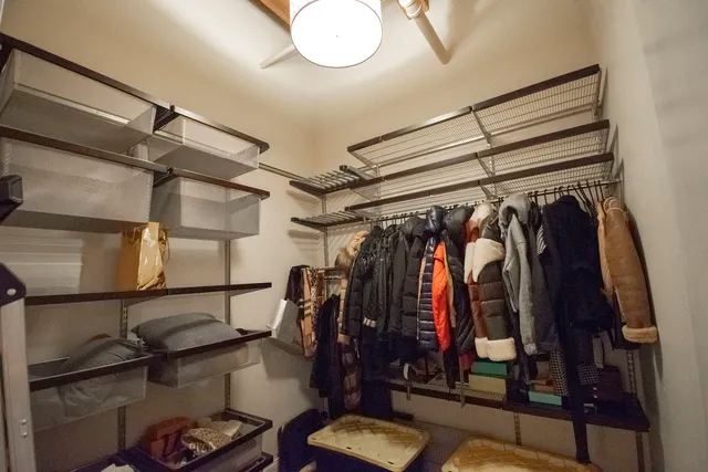 a view of walk in closet with clothes and shoes