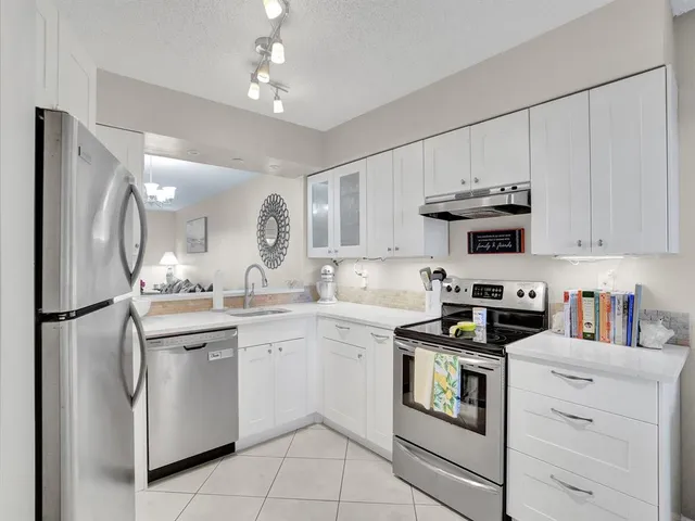 a kitchen with white cabinets stainless steel appliances and sink