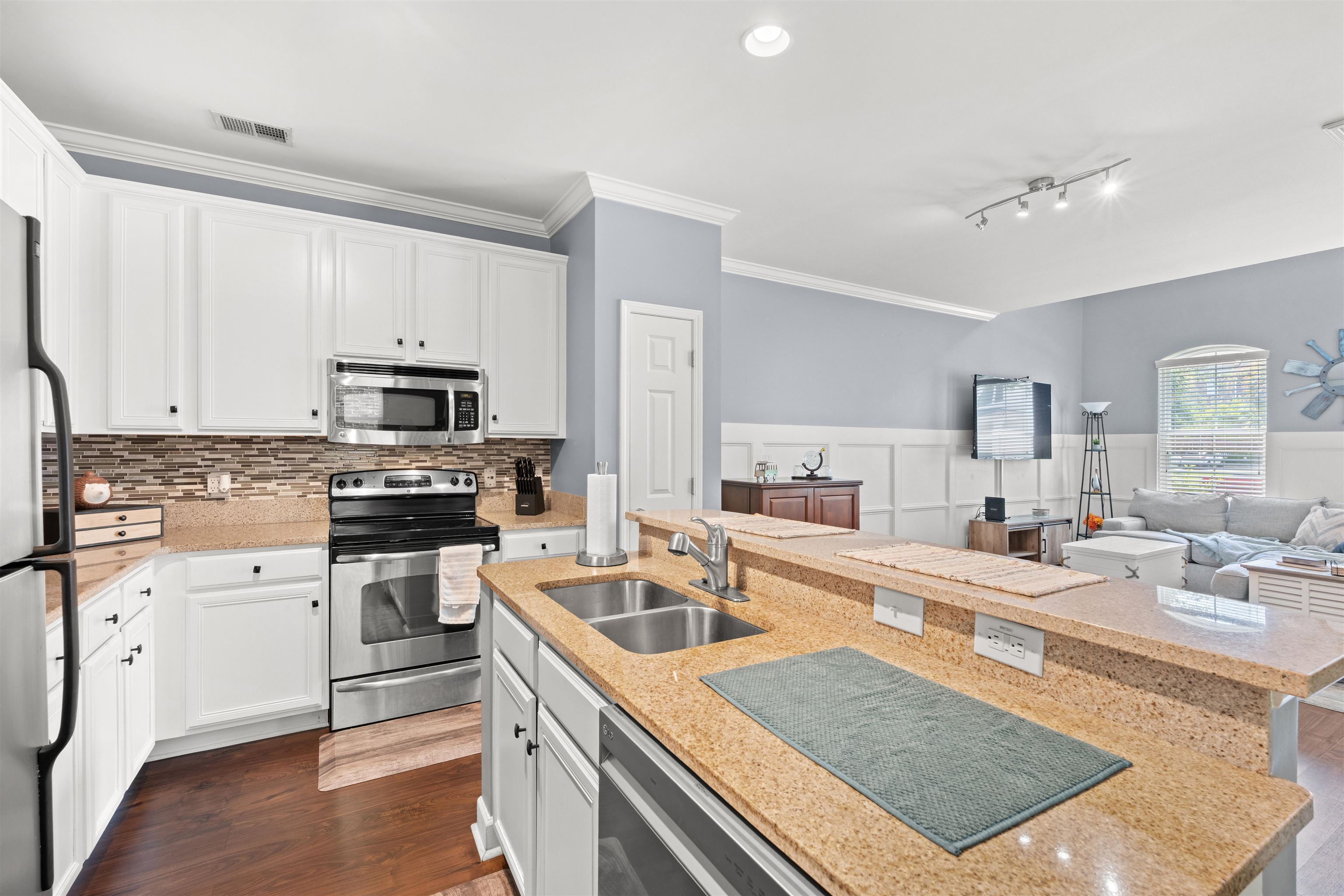3512 Alexandria Avenue, Unit 18 Myrtle Beach, SC 29577 - Photo 9 of 31 Kitchen featuring stainless steel appliances, white cabinetry, light stone counters, crown molding, and a wainscoted wall