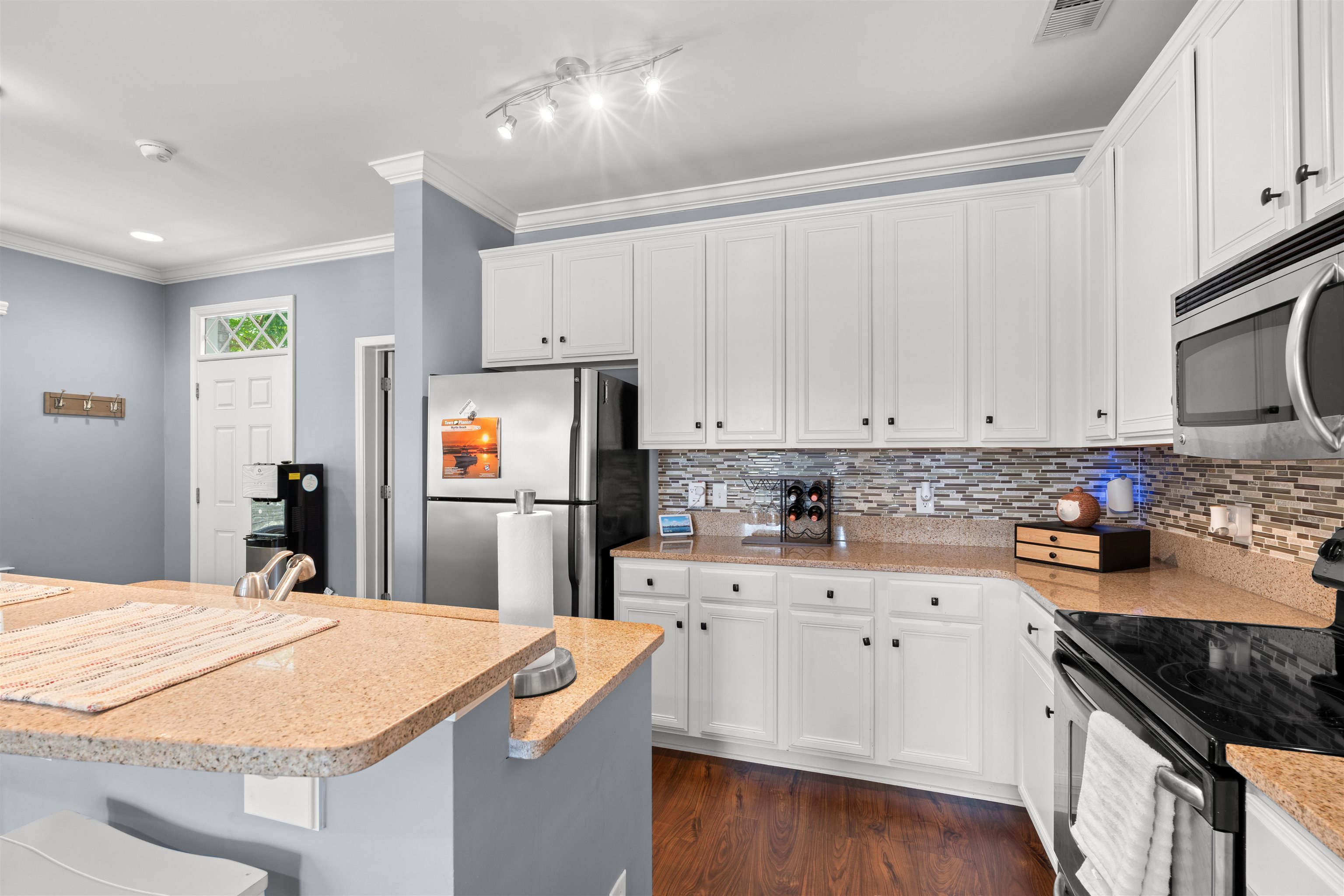 3512 Alexandria Avenue, Unit 18 Myrtle Beach, SC 29577 - Photo 10 of 31 Kitchen with appliances with stainless steel finishes, white cabinets, light stone countertops, crown molding, and decorative backsplash