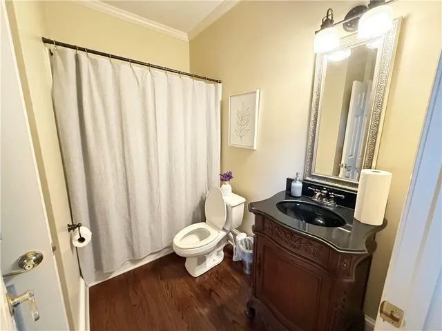 a bathroom with toilet a sink and a mirror