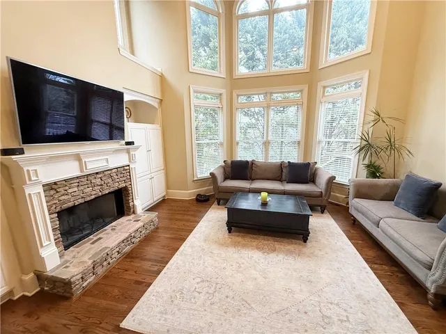 a living room with furniture a flat screen tv and a fireplace