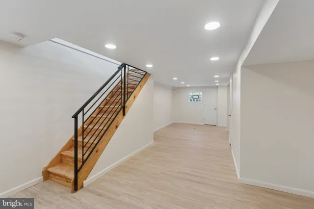 an entryway in a hall with wooden floor and a hallway