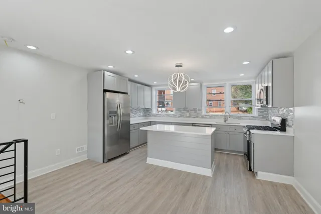 a kitchen with cabinets and wooden floor