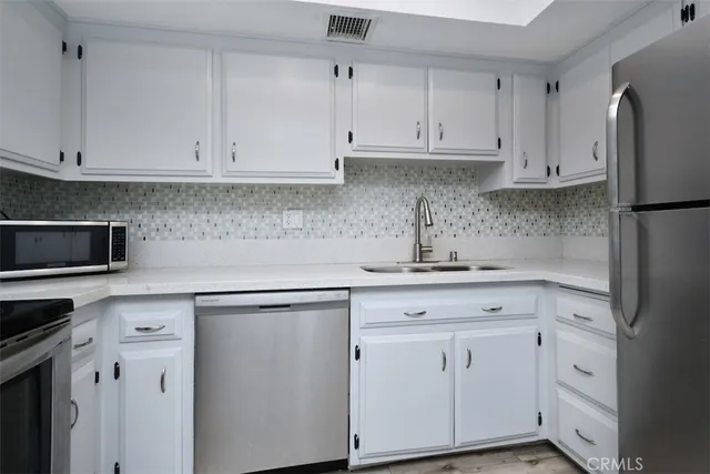a kitchen with white cabinets and white appliances