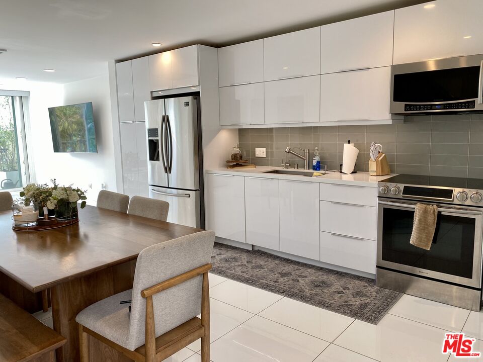 23901 Civic Center Way, Unit 114 Malibu, CA 90265 - Photo 1 of 38 a kitchen with stainless steel appliances a stove a sink a microwave a refrigerator and cabinets
