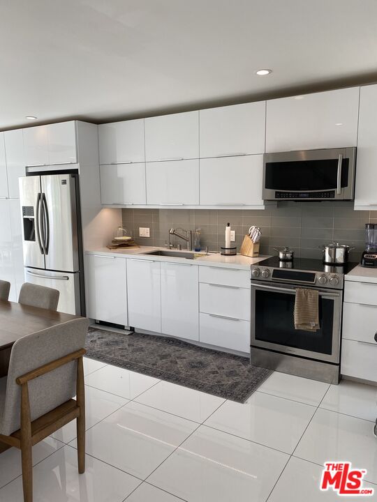 23901 Civic Center Way, Unit 114 Malibu, CA 90265 - Photo 2 of 38 a kitchen with stainless steel appliances a stove a sink and a microwave