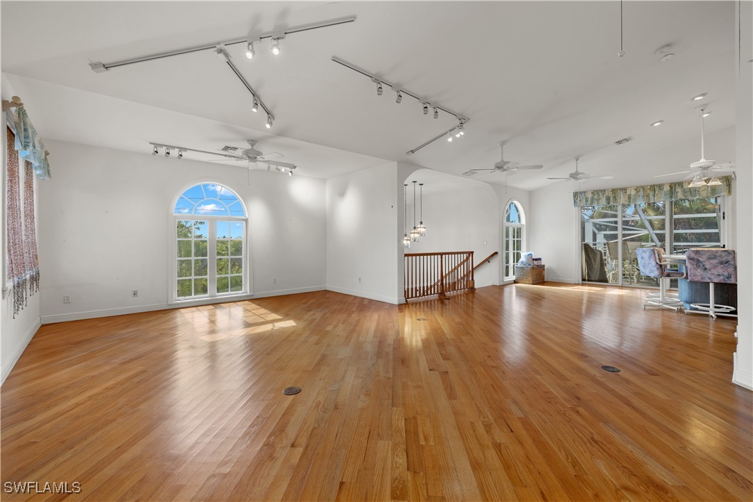 431 Rabbit Road Sanibel, FL 33957 - Photo 6 of 41 an empty room with wooden floor and windows