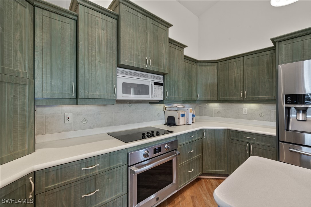 431 Rabbit Road Sanibel, FL 33957 - Photo 7 of 41 a kitchen with stainless steel appliances a sink a stove a microwave and cabinets