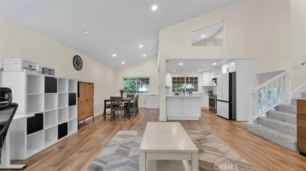 a view of kitchen with kitchen island stainless steel appliances refrigerator stove dining table and chairs