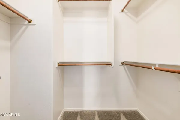 a view of walk in closet with empty racks