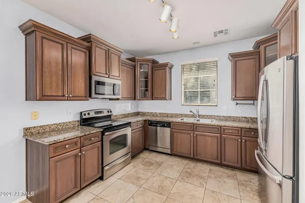 a kitchen with stainless steel appliances granite countertop a stove sink and cabinets