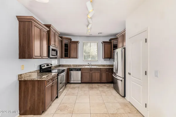 a large kitchen with a stove a refrigerator and a sink