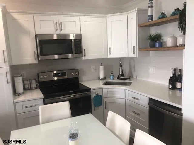 a kitchen with stainless steel appliances a sink a stove and microwave