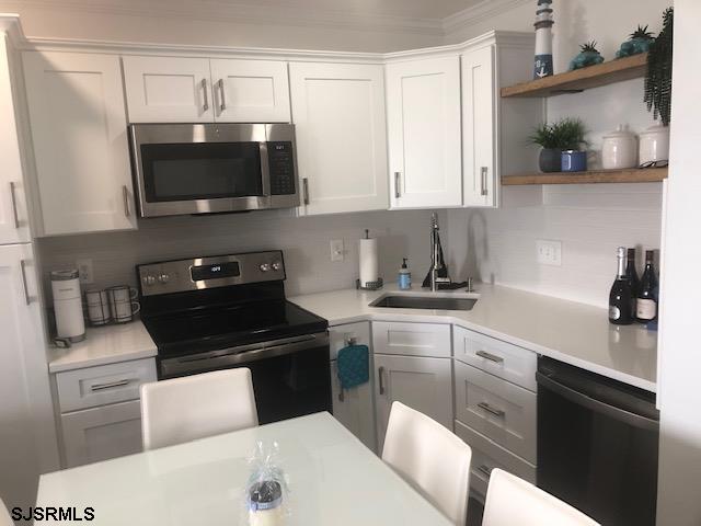 203 East Brigantine Avenue, Unit 206 Brigantine, NJ 08203 - Photo 7 of 14 a kitchen with stainless steel appliances a sink a stove and microwave
